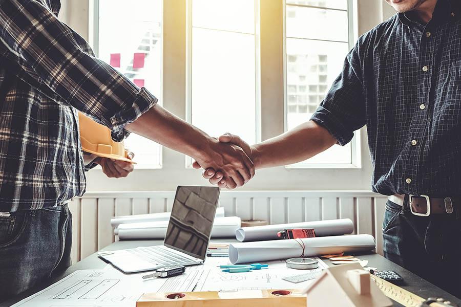 Specialized Business Insurance - Closeup Of Engineer and Contractor Shaking Hands on the Success of a Contracting Project They Worked on Together
